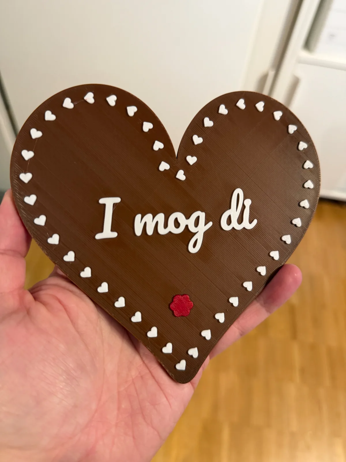 Echt 3D-gedrucktes braunes Dekoherz mit weißer Schrift und Herzrand