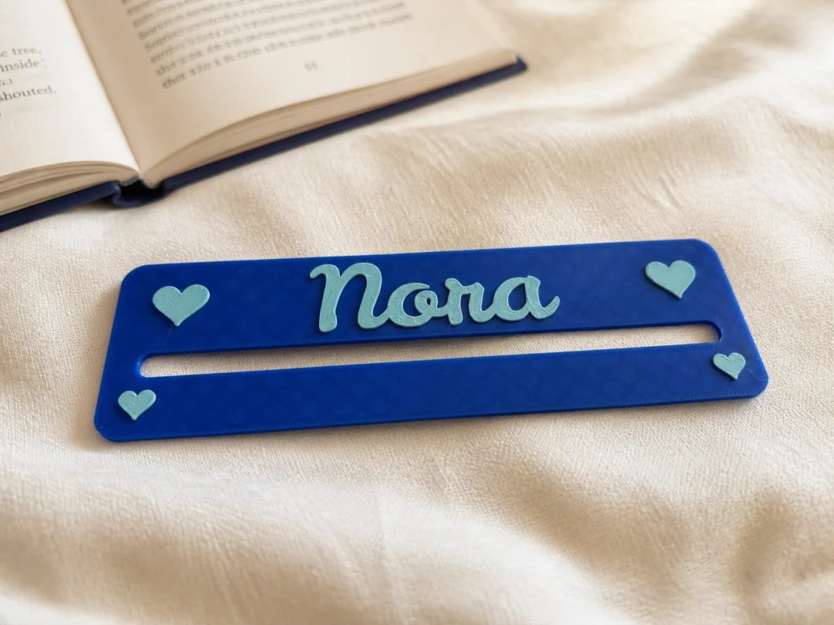 Fertig gedruckte blaue Lesehilfe mit dem Namen Nora und mintfarbenen Herzen
